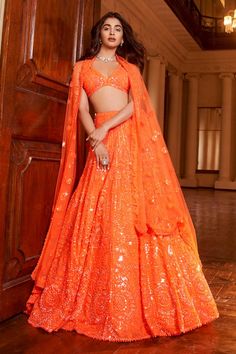 Neon orange lehenga with attached can-can, in a net base with all-over tonal sequin embroidery in an abstract pattern. Comes with matching V neck embroidered padded blouse and dupatta.
Components: 3
Pattern: Embroidery
Type Of Work: Sequin
Neckline: V neck
Sleeve Type: Sleeveless
Fabric: Net
Color: Orange
Other Details: 
Sheer dupatta with sequin embroidery on the border
Plunge V neckline
Closure: Lehenga: Side zip
Occasion: Bride - Aza Fashions Orange Dress Outfits, Seema Gujral, Orange Lehenga, Engagement Lehenga, Neon Abstract, Net Embroidery, Wedding Lehenga Designs, Pooja Hegde, Indian Dresses Traditional