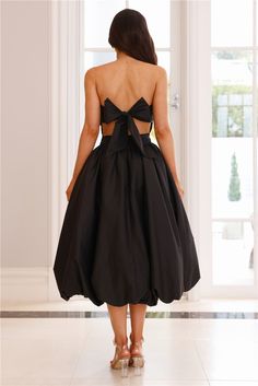 the back of a woman's black dress with cut outs and bow at the waist