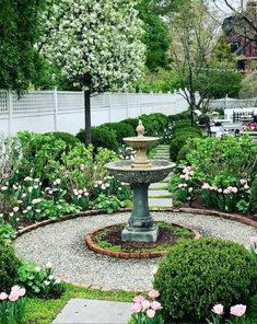 a garden with a fountain surrounded by flowers