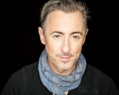 a man with grey hair wearing a scarf