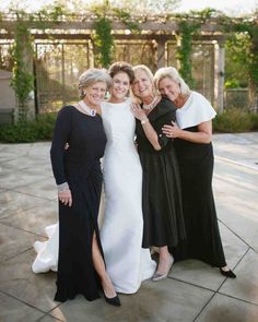 three women pose for the camera in their dresses