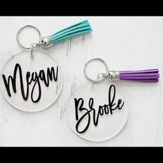 two personalized keychains with tassels on them, one is purple and the other is green