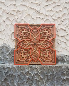 an intricately designed tile on the side of a building