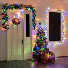 a christmas tree with lights and presents in front of a door decorated for the holiday season