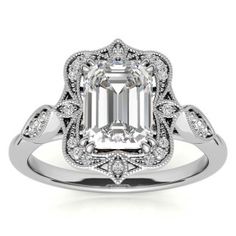 an emerald cut diamond engagement ring with filigrees on the shoulders and sides