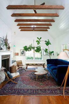 a living room filled with furniture and a rug on top of a hard wood floor