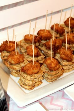 small appetizers are arranged on a white platter with toothpicks stuck in them