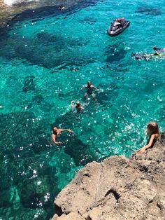 several people swimming in the clear blue water