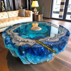 a living room with a couch and table made out of blue agate glass in the center