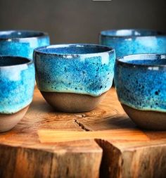 five blue bowls sitting on top of a wooden table