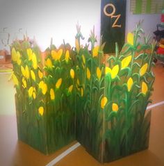 two vases made out of paper with yellow flowers on the top and green stems in the bottom