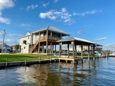 a house sitting on top of a lake next to a dock