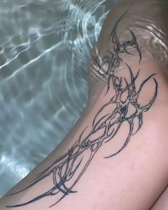 a woman's legs in the water with a tattoo on her arm and leg