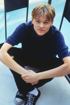 a young man sitting on top of a chair