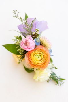 an arrangement of flowers on a white surface