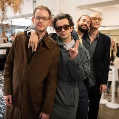 three men standing next to each other posing for the camera