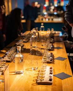 a long wooden table topped with lots of glasses