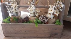 a wooden box filled with flowers and pine cones