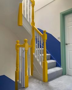 the stairs are painted yellow and white with blue carpet on each side, along with an open door