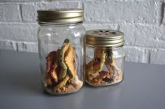 two jars filled with food sitting on top of a table