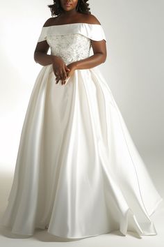 a woman in a white wedding dress posing for the camera with her hands on her hips