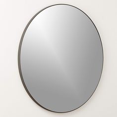 a round mirror mounted to the side of a wall