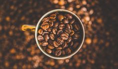 a cup filled with coffee beans sitting on top of a table