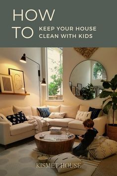 a kid is sitting on the floor in front of a white couch and coffee table