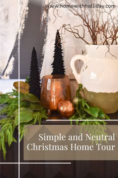 a white vase sitting on top of a table next to a christmas tree and other decorations