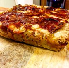 a pizza sitting on top of a wooden cutting board