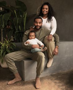 a man and woman sitting on a bench with a baby