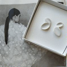 an open box with two rings in it on top of a table next to other items