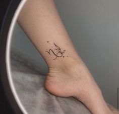 a woman's foot with a small tattoo on the side of her left leg