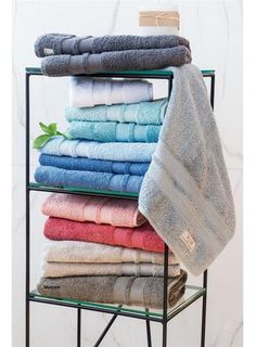 towels are stacked on a rack in front of a marble wall