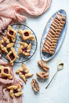 several pastries are sitting on a cooling rack next to a pink towel and spoon