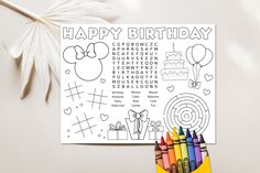 a happy birthday coloring page with crayons and colored pencils next to it