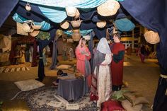 two women standing under a canopy in a room