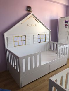 there is a doll house bed and crib next to each other in the room