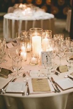 the table is set with wine glasses and place cards