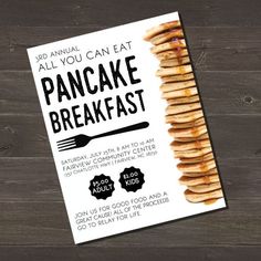 an advertisement for pancakes with fork and spoon on wooden table next to wood planks