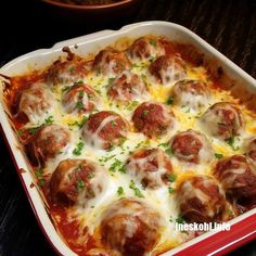 a casserole dish filled with meatballs and cheese