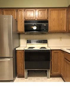 an empty kitchen with stainless steel appliances and wood cabinets, including a refrigerator freezer