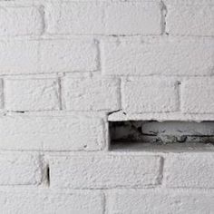 a white brick wall with a hole in the middle that appears to have been built into it