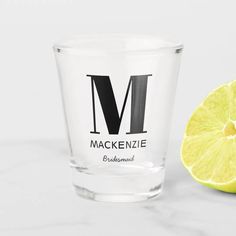 a lemon next to a shot glass with the word mackenzie on it