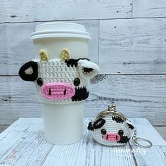 a coffee cup holder with a cow head on it and a small purse in front of it