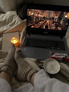 a person laying in bed with their feet up on the edge of a laptop computer