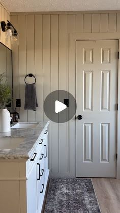 a kitchen with white cabinets and black accents on the counter top, along with a gray area rug