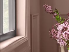 a vase filled with pink flowers next to a window