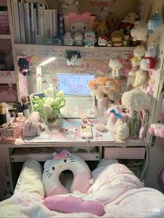 a desk with a hello kitty stuffed animal on it and many other items in the room