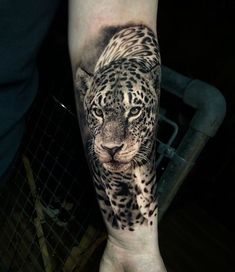 a man's arm with a tattoo of a leopard on it